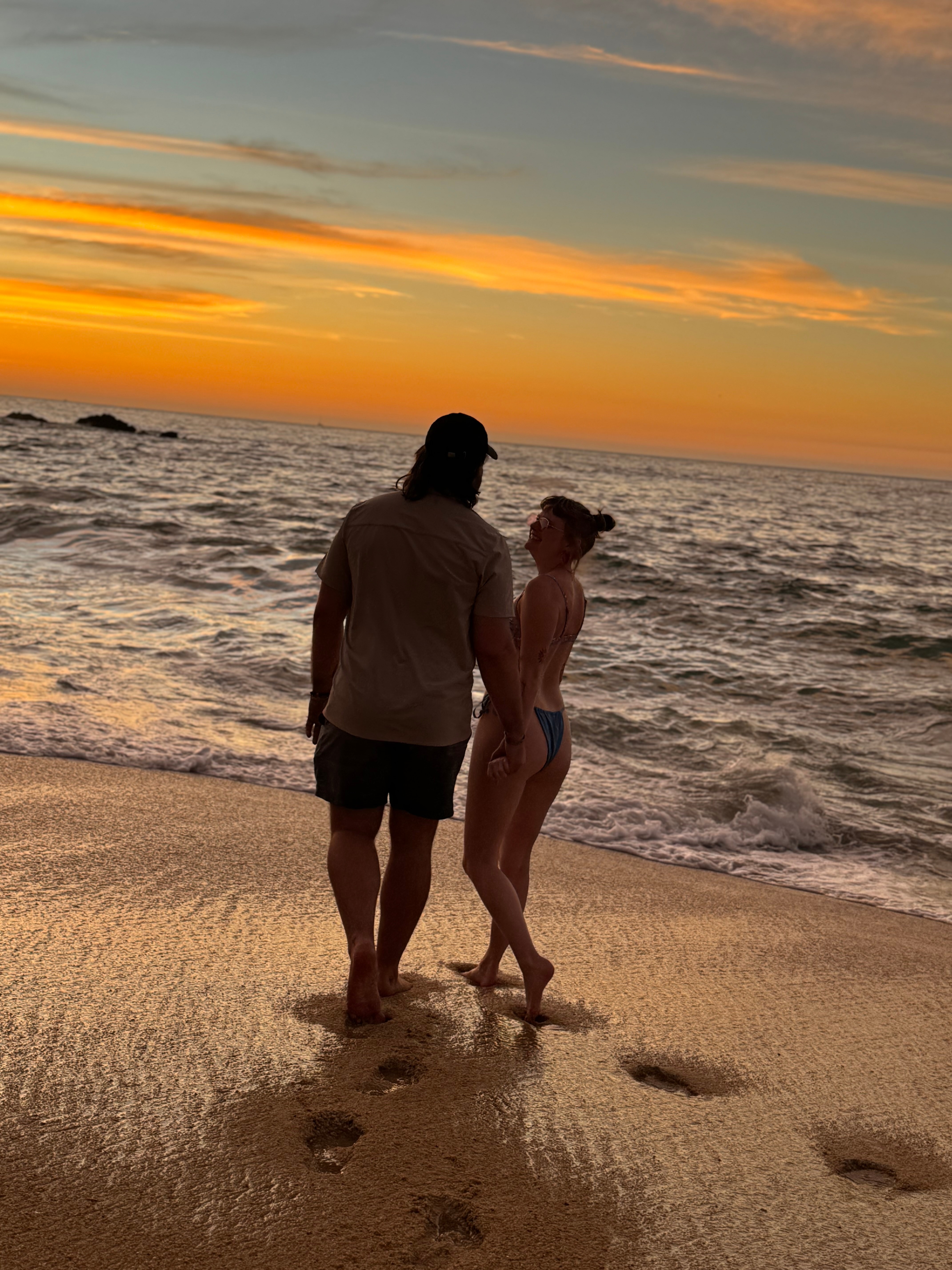 Chris and Paige walking at sunset on the beach