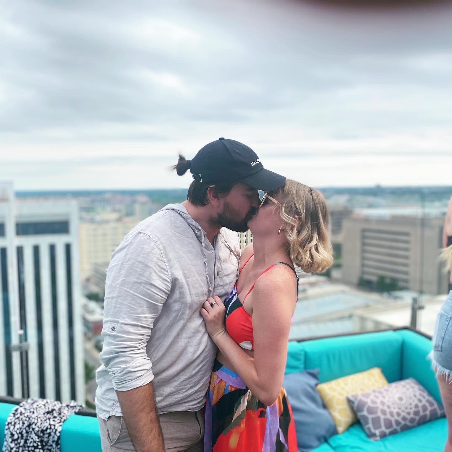 Chris and Paige kissing on a rooftop