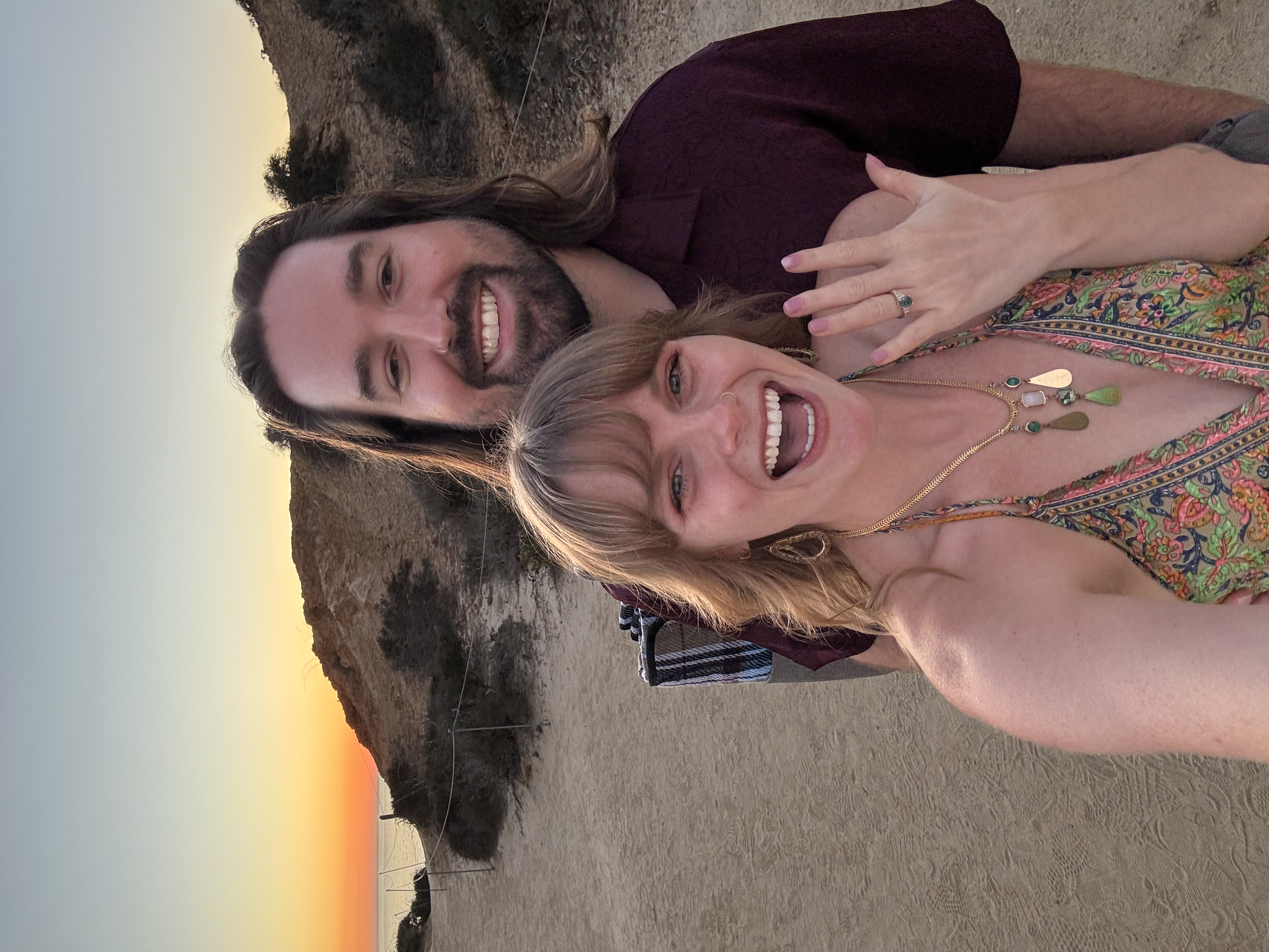 Chris and Paige showing off the engagement ring at sunset